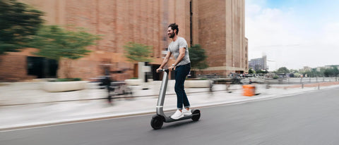 Bo riding past a building